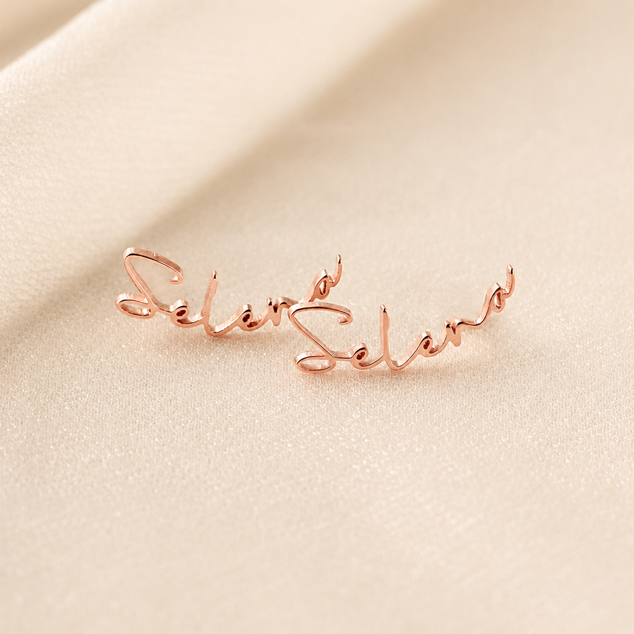 Rose gold bracelet with 'Selen' engraving on a beige background